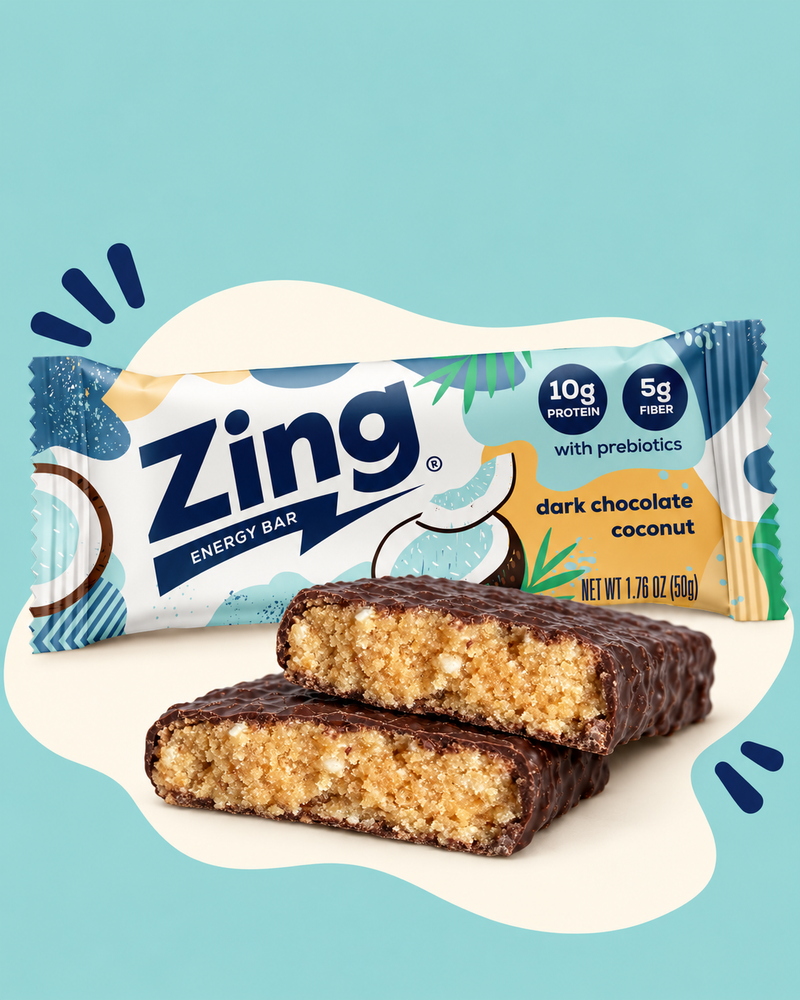 Wrapped Zing Dark Chocolate Coconut bar behind two stacked bar halves showing the coconut filling.