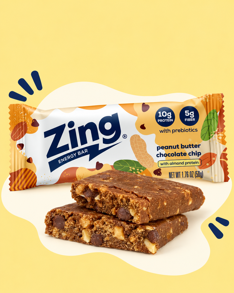 Wrapped Zing Peanut Butter Chocolate Chip bar behind two stacked bar halves showing chocolate chips and peanut pieces.